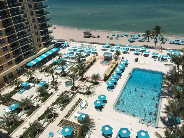 a patio with tables and chairs under an umbrella