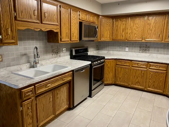 a kitchen with stainless steel appliances granite countertop a sink stove and microwave