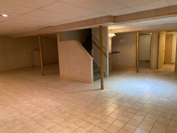 an empty room with white walls and stairs
