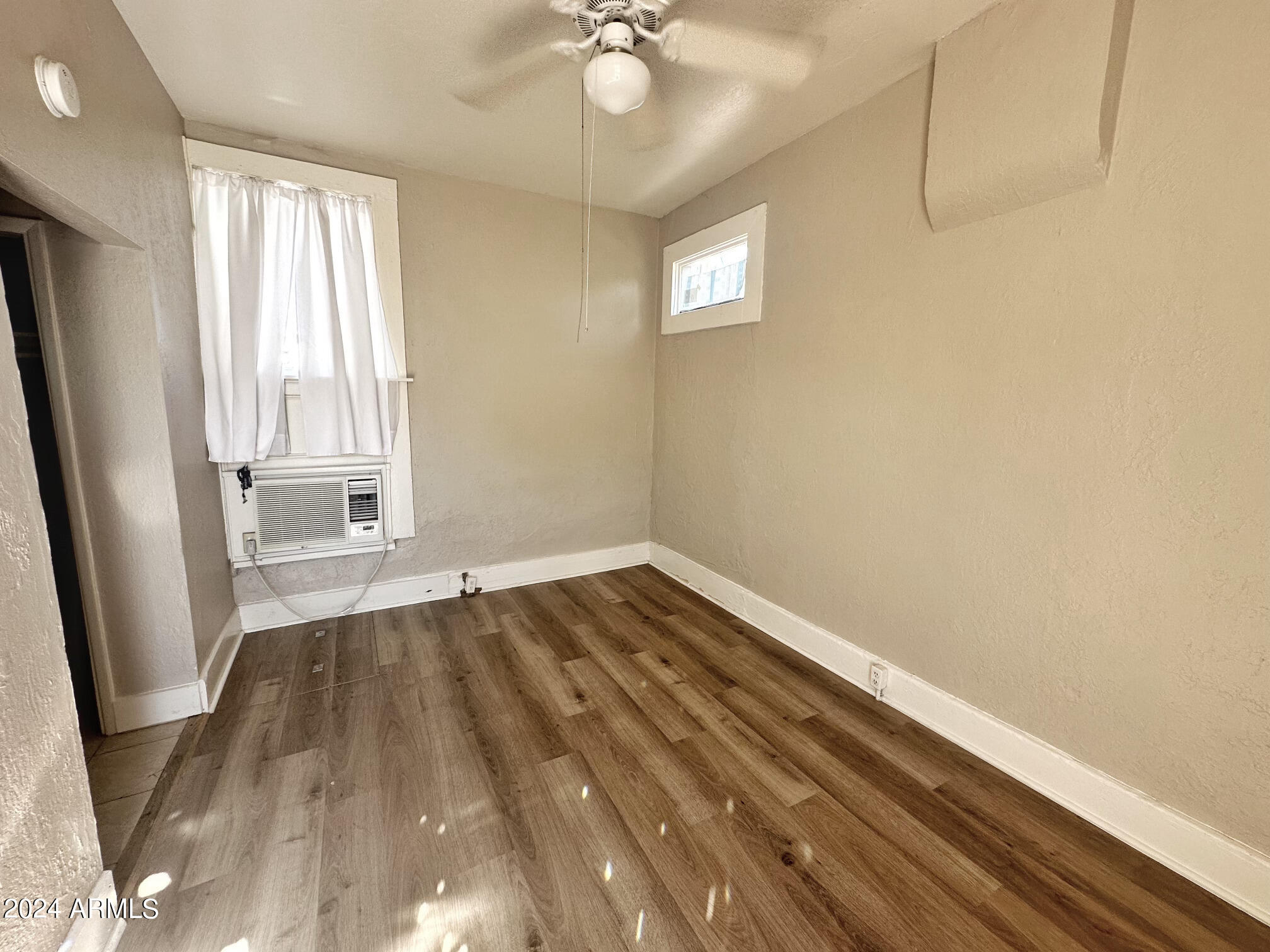 1019 West Woodland Avenue, Unit 9 Phoenix, AZ 85007 - Photo 4 of 6 a view of empty room with wooden floor and fan