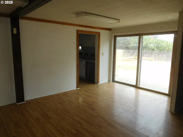 a view of an empty room with wooden floor and closet