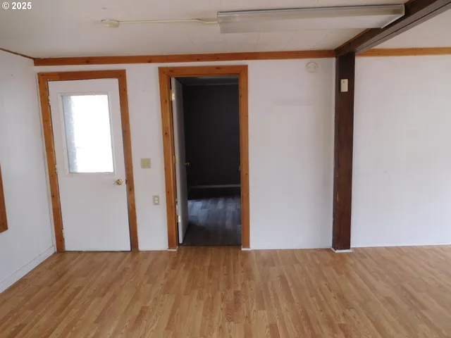 a view of a room with wooden floor and door