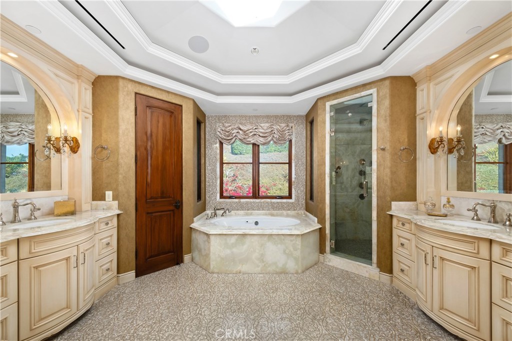 32040 Cape Point Drive Rancho Palos Verdes, CA 90275 - Photo 45 of 70 a spacious bathroom with a double vanity sink a mirror a bathtub and next to a window