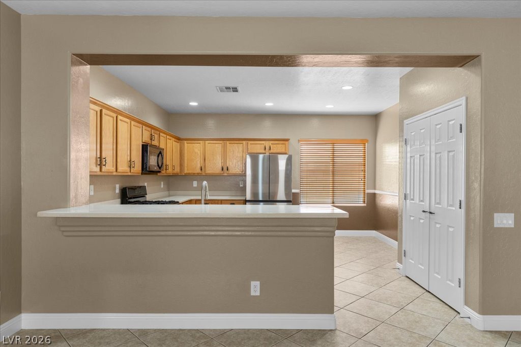 2627 Dirleton Place Henderson, NV 89044 - Photo 7 of 42 The breakfast bar is perfect for casual dining, serving appetizers, or gathering with family and friends while entertaining.
