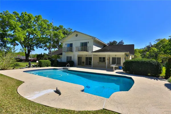 a view of a house with swimming pool and yard