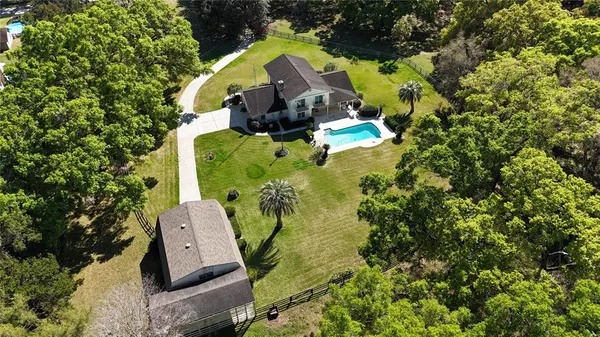 an aerial view of a house with a yard and swimming pool