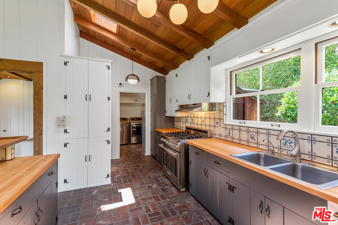 13238 Riviera Ranch Road Los Angeles, CA 90049 - Photo 13 of 28 a large kitchen with stainless steel appliances granite countertop a sink stove and refrigerator