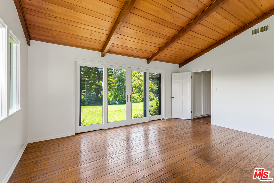 13238 Riviera Ranch Road Los Angeles, CA 90049 - Photo 17 of 28 a view of an empty room with wooden floor and a window