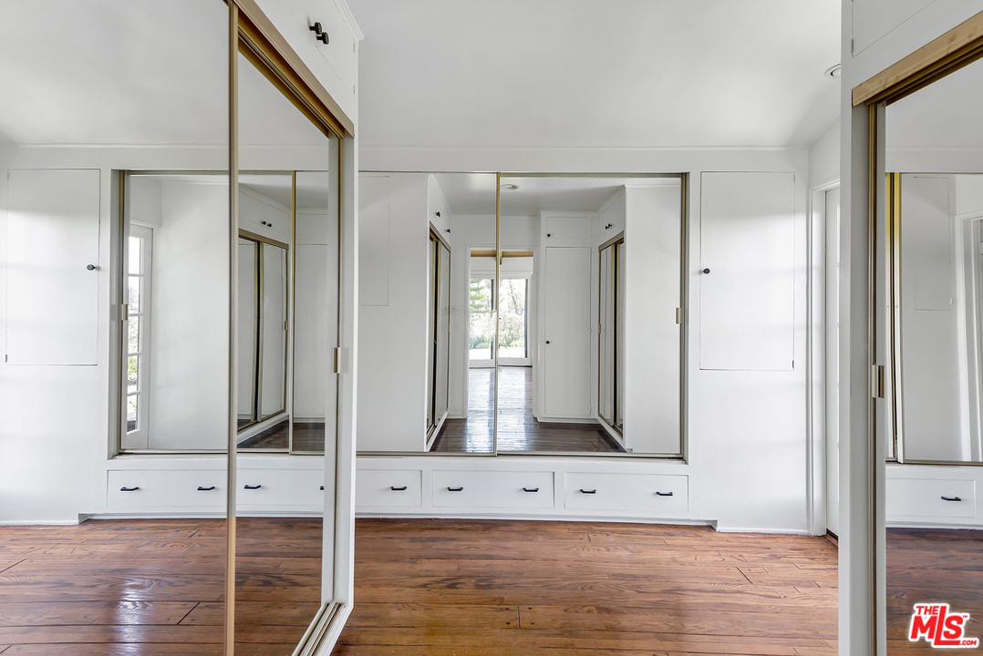 13238 Riviera Ranch Road Los Angeles, CA 90049 - Photo 18 of 28 a view of room with a mirror and a wooden floor