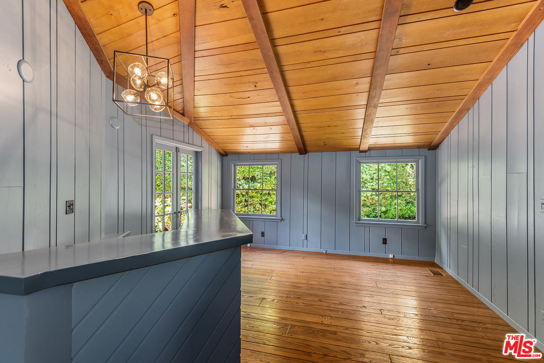 13238 Riviera Ranch Road Los Angeles, CA 90049 - Photo 20 of 28 an empty room with wooden floor and windows
