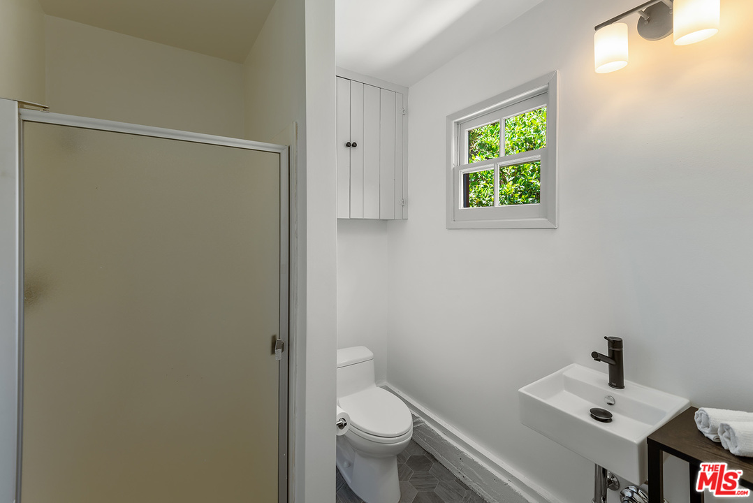 13238 Riviera Ranch Road Los Angeles, CA 90049 - Photo 22 of 28 a bathroom with a toilet a sink and a window