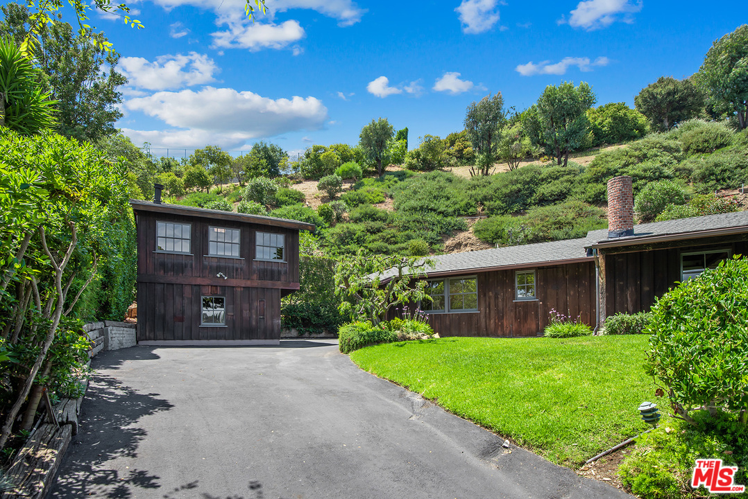 13238 Riviera Ranch Road Los Angeles, CA 90049 - Photo 5 of 28 a front view of a house with a garden