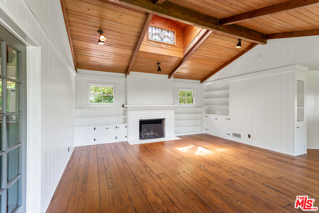 13238 Riviera Ranch Road Los Angeles, CA 90049 - Photo 7 of 28 a view of a livingroom with wooden floor and a fireplace