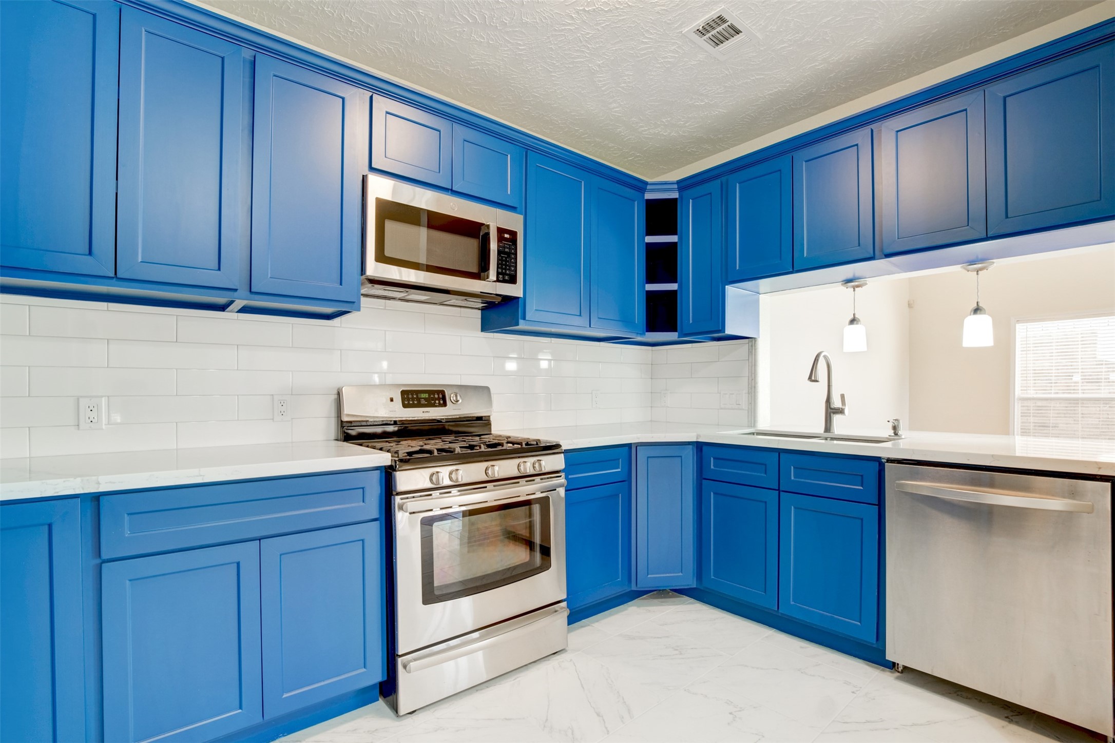 11840 Spring Grove Drive Houston, TX 77099 - Photo 9 of 27 Modern kitchen with gas stove, dishwasher, and pendant lighting