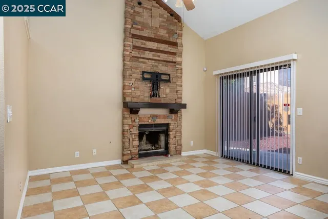 a view of an empty room with a fireplace and a window