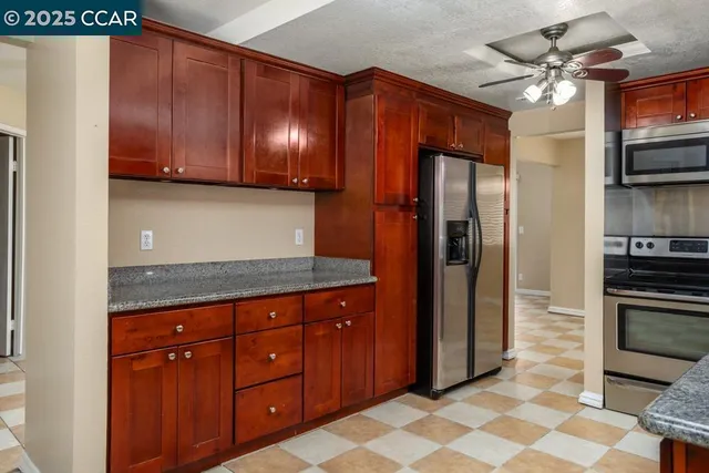a kitchen with stainless steel appliances granite countertop a refrigerator and a sink