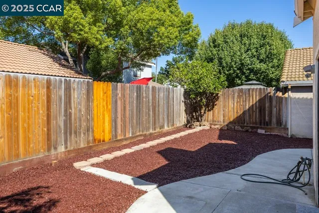 a view of backyard with wooden fence and large trees