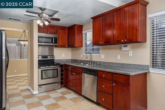 a kitchen with stainless steel appliances granite countertop a sink stove and refrigerator