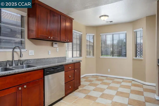 a kitchen with stainless steel appliances granite countertop cabinets a sink and a window