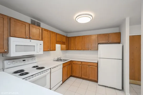 a kitchen with a sink a refrigerator and cabinets
