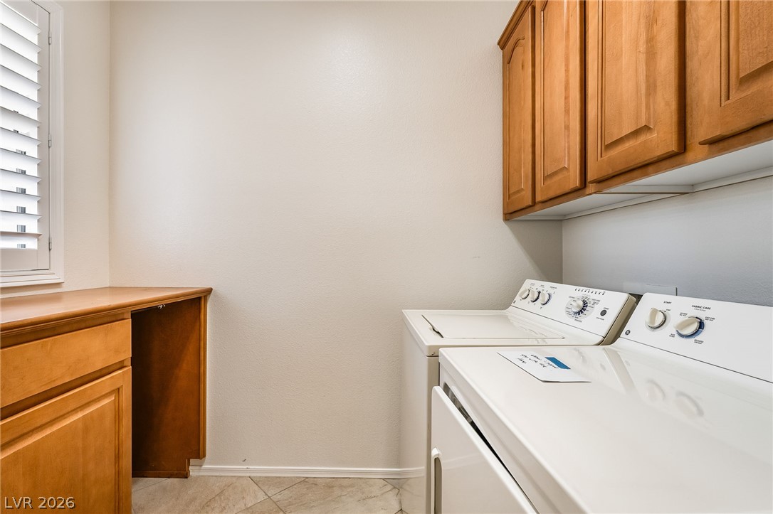 3033 Hartsville Road Henderson, NV 89052 - Photo 36 of 41 Functional laundry room featuring warm wood cabinetry, practical counter space, and durable tile flooring.