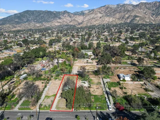 an aerial view of residential houses with outdoor space and trees
