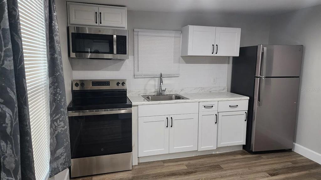 837 Ethyl Street, Unit B Brandon, FL 33511 - Photo 10 of 12 a kitchen with cabinets stainless steel appliances and wooden floor