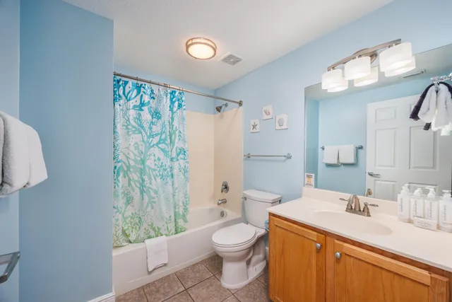 a bathroom with a granite countertop sink mirror vanity and toilet