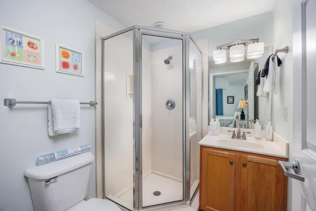a bathroom with a granite countertop sink mirror vanity and toilet