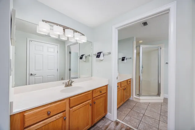 a spacious bathroom with a double vanity sink mirror and shower