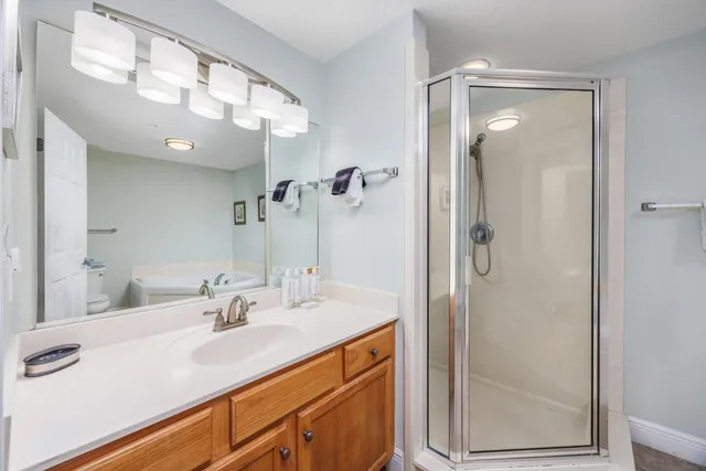 a bathroom with a shower sink vanity and mirror
