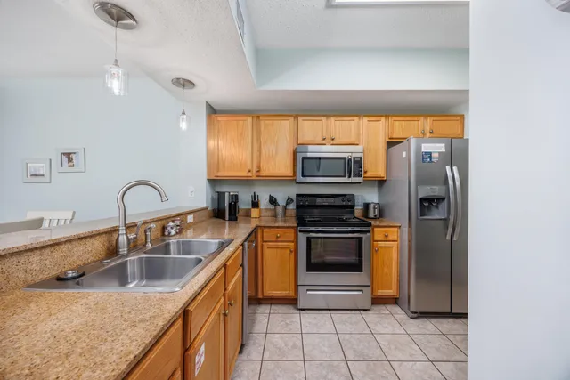 a kitchen with stainless steel appliances granite countertop a sink a stove and a refrigerator