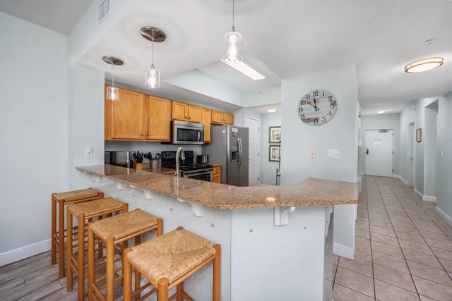 a view of a kitchen with kitchen island granite countertop a stove and a refrigerator