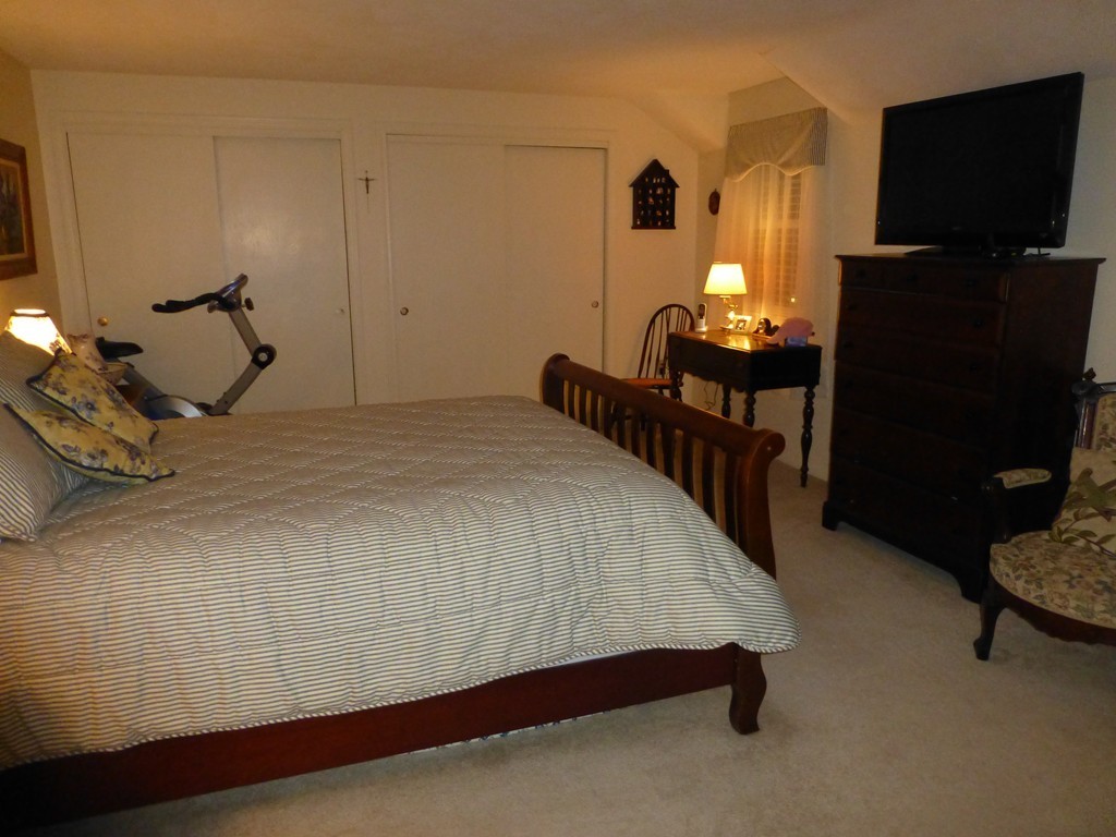 91 Drummer Road, Unit 91 Acton, MA 01720 - Photo 15 of 17 a bedroom with a bed tv and a mirror
