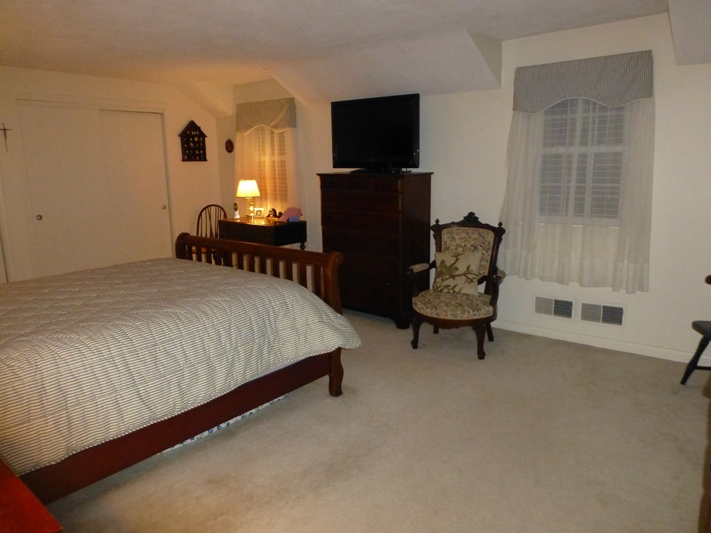 91 Drummer Road, Unit 91 Acton, MA 01720 - Photo 16 of 17 a bedroom with a bed and a chair in it