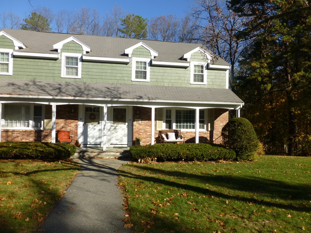 91 Drummer Road, Unit 91 Acton, MA 01720 - Photo 4 of 17 a front view of a house with a yard table and chairs