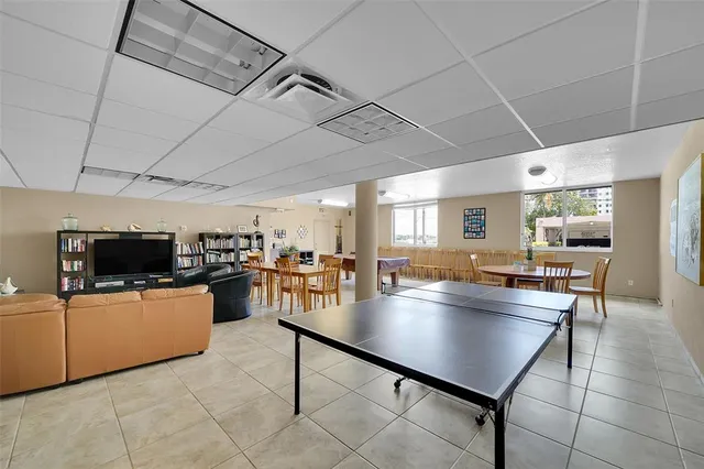 a living room with stainless steel appliances furniture and a kitchen view