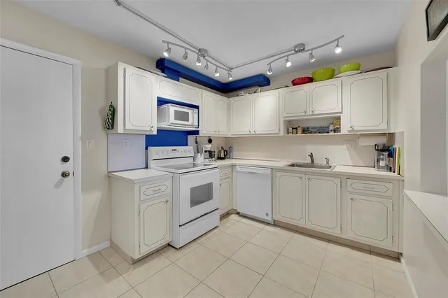 a kitchen with granite countertop a sink cabinets stainless steel appliances and a window