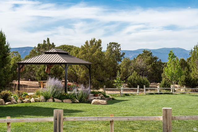 11550 Pigeon Hollow Road Spring City, UT 84662 - Photo 24 of 85 Expansive green lawn with a wooden split-rail fence, a metal gazebo, and surrounding mature trees