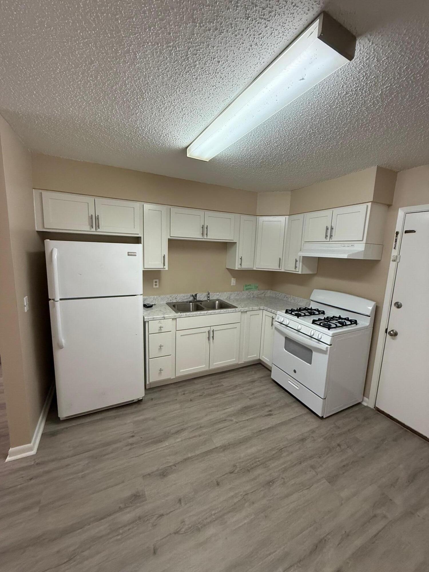 830 Cardinal Street, Unit 2 Fort Walton Beach, FL 32547 - Photo 4 of 11 a kitchen with white cabinets and white appliances