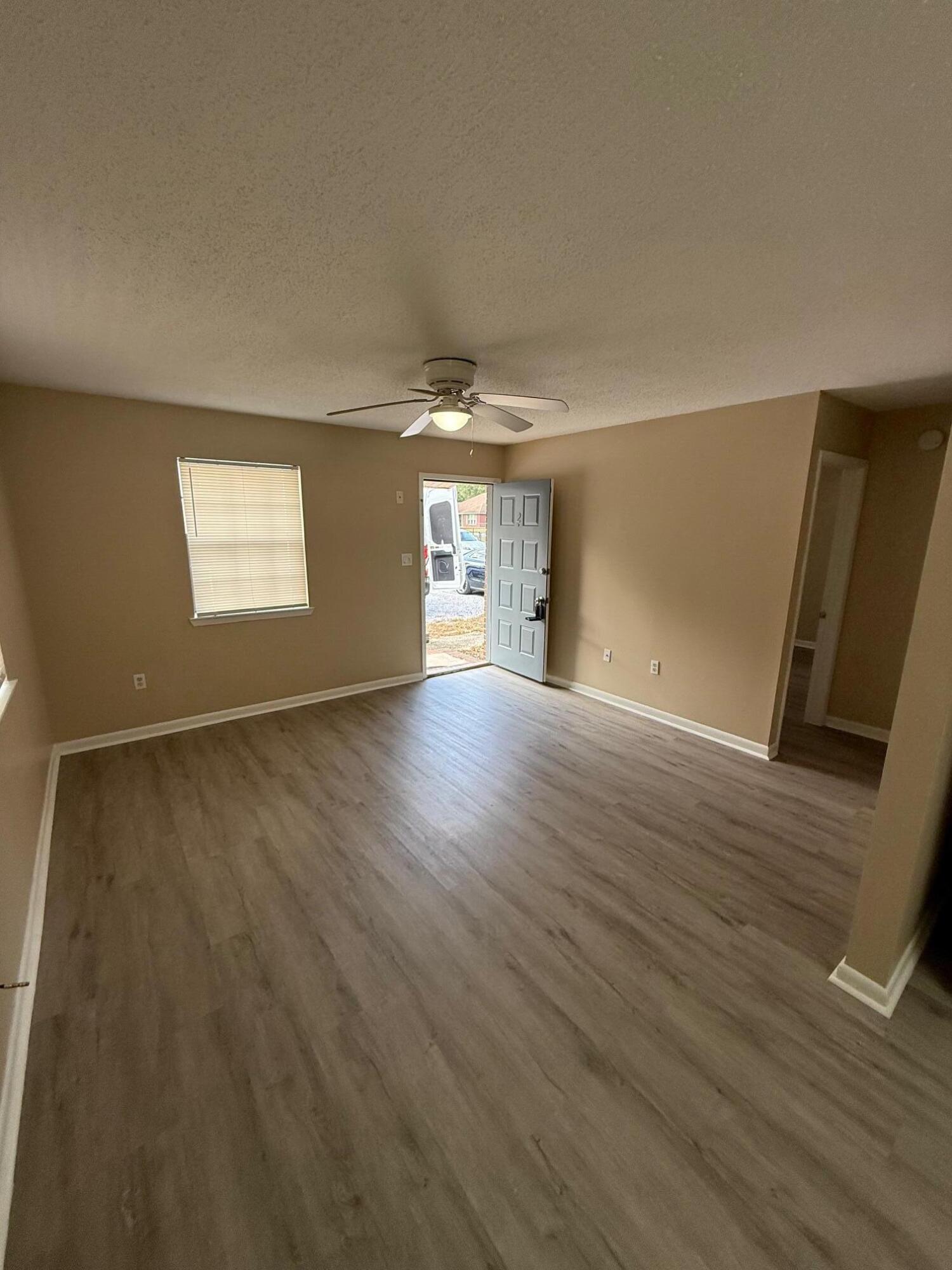 830 Cardinal Street, Unit 2 Fort Walton Beach, FL 32547 - Photo 5 of 11 an empty room with wooden floor and windows