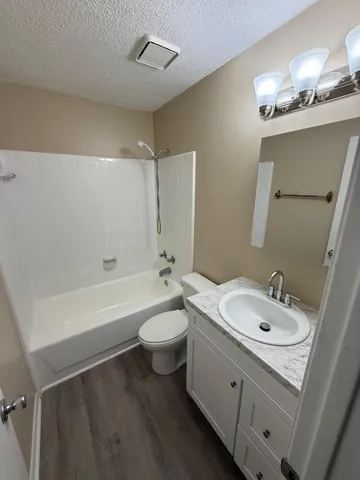 a bathroom with a double vanity sink a toilet a mirror and shower