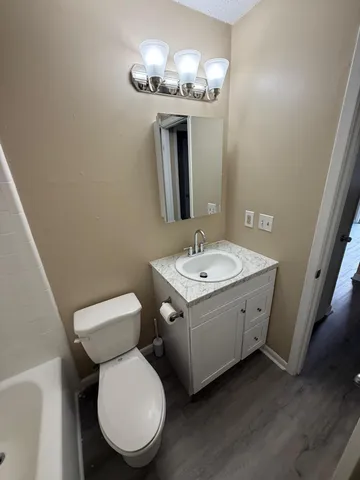 a bathroom with a toilet sink and mirror