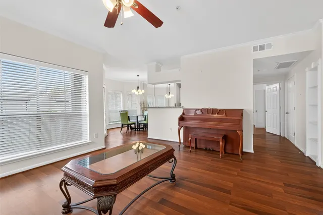 a room with wooden floor pool table and windows