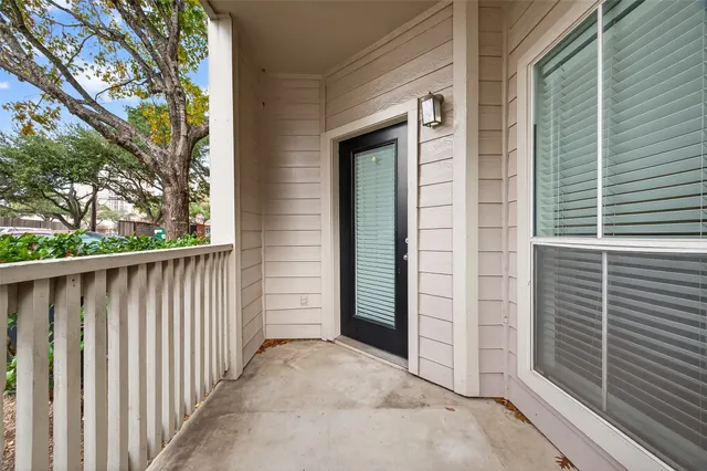 a view of a porch with a door and wooden fence