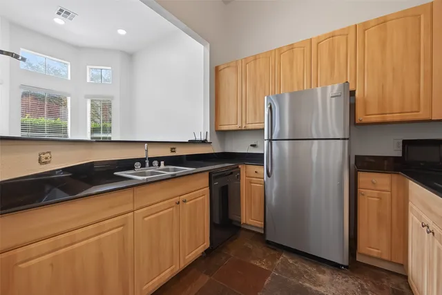 a kitchen with a refrigerator sink and cabinets