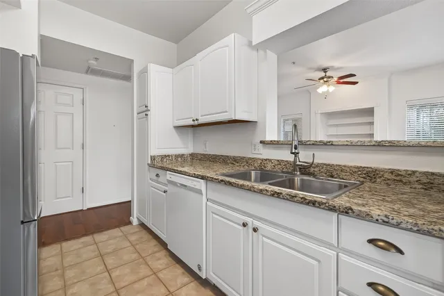 a kitchen with granite countertop a sink a stove and cabinets