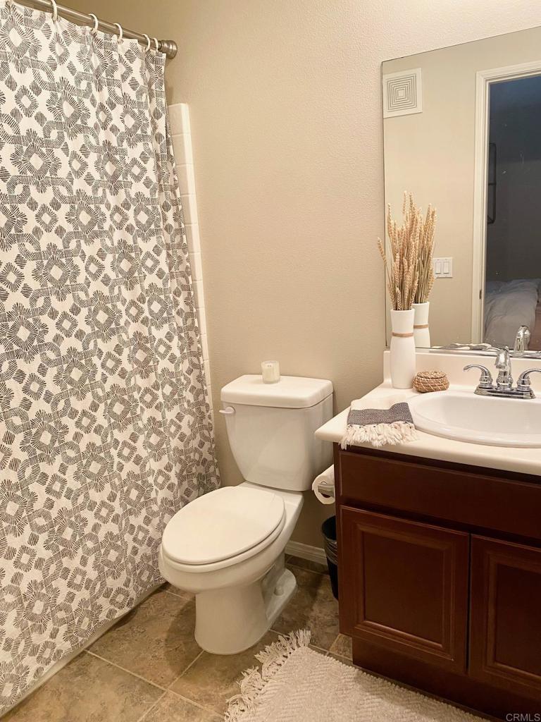 69 Via Sovana Santee, CA 92071 - Photo 12 of 17 a bathroom with a sink toilet and mirror