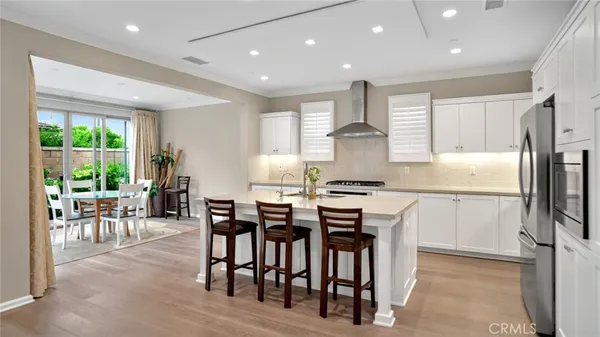 a kitchen with stainless steel appliances granite countertop table chairs refrigerator and cabinets