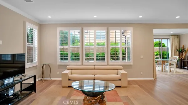 a living room with furniture a flat screen tv and a large window